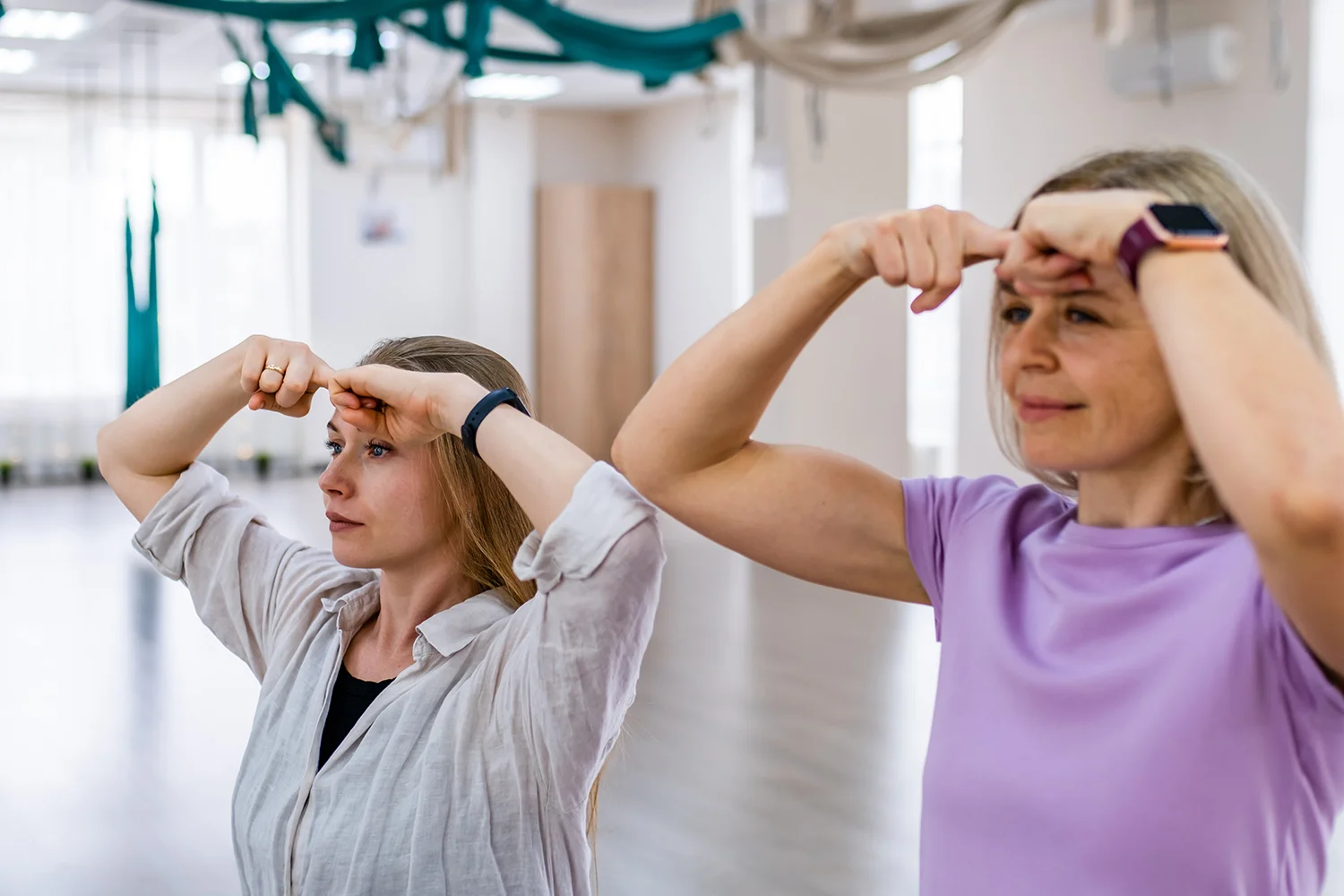 two women practicing facial exercises in a studio